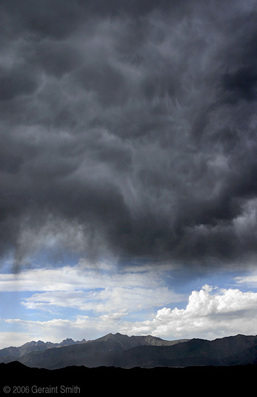 A window in the storm over the Great Sand Dunes National Park with a view of Crestone Peak 