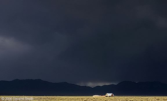 House on the mesa with Arroyo Seco and El Salto and a big storm cloud