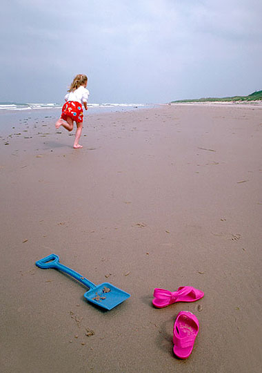 Beach girl, beach dreaming, Bamburgh beach Northumberland, UK