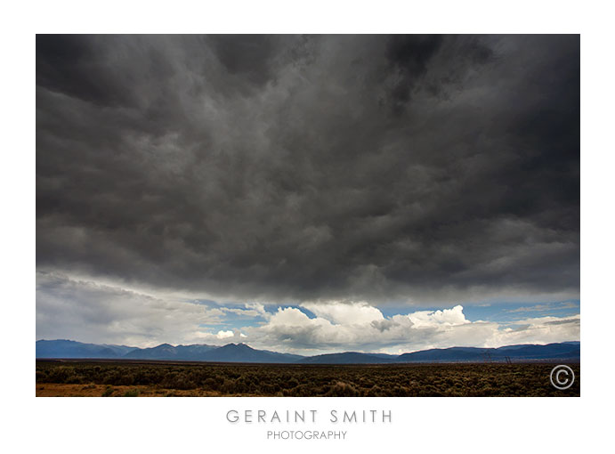 Across the gorge rim to the mountains, under a brooding sky