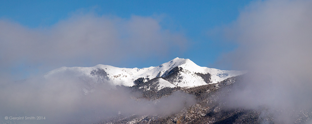 Vallecito Peak breaking through the rising valley fog taos new mexico