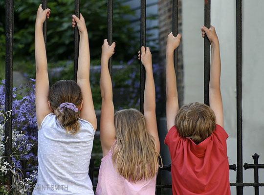 Kids just hanging out in Lewes, East Sussex, England. We were walking down the street and the kids in unison hung on the gate and admired the garden beyond. 