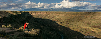 Photographer on a photo tour with a stop to photograph the shadows climbing up the Rio Grande Gorge rim after a day in Abiquiu, New Mexico